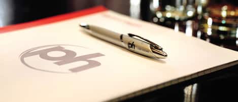 A pen on a piece of paper with a logo.