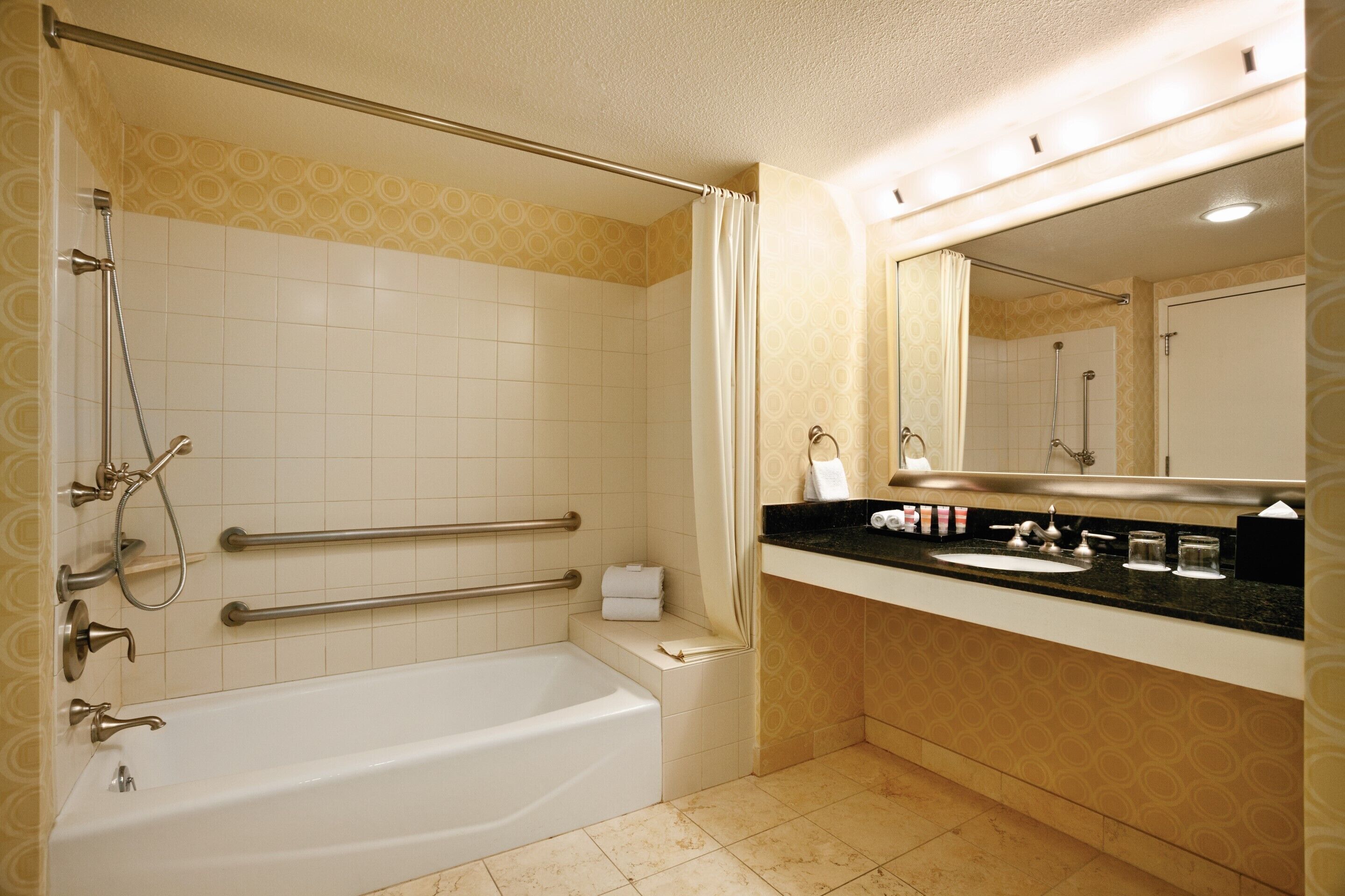 A bathroom with a bathtub, a sink, a mirror, and a shower.