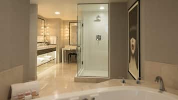 A modern bathroom with a large bathtub, a glass-enclosed shower, and a vanity with a mirror.