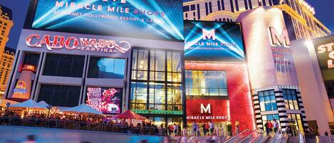 Un edificio grande con varios letreros que indican 'Miracle Mile Shops' y 'Planet Hollywood'.