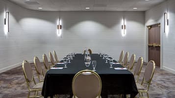 A conference room with a long table, chairs, and a door.