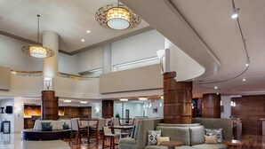 A spacious lobby with a curved seating area, wooden pillars, and modern lighting fixtures. - Marriott Albuquerque (Albuquerque)