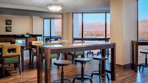 A hotel lobby with a wooden floor, a bar area, and a large window offering a mountain view. - Marriott Albuquerque (Albuquerque)