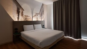 A modern hotel room with a large bed, a nightstand, and a wall-mounted artwork depicting a building. - B&B Hotel Treviso Al Fogher (Treviso)
