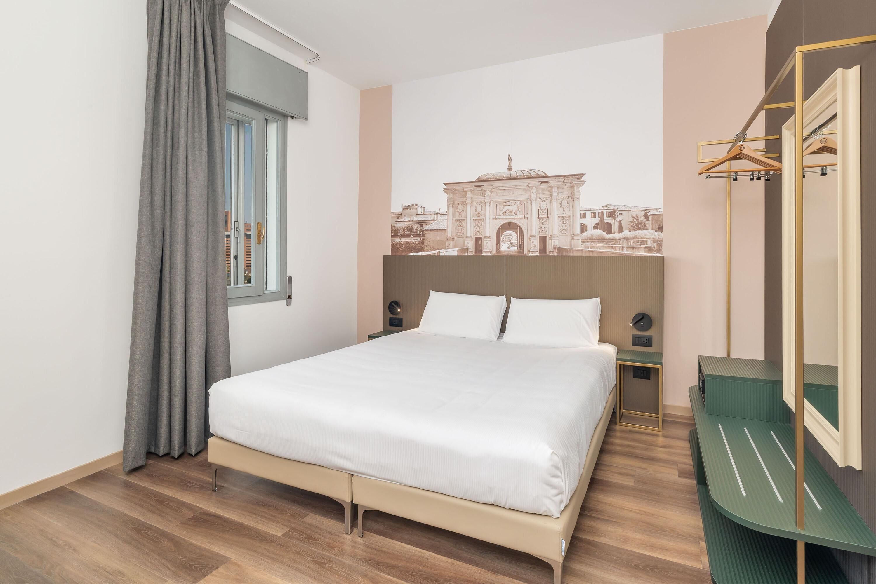 Ein ordentlich eingerichtetes Schlafzimmer mit Bett, Kommode und Spiegel.