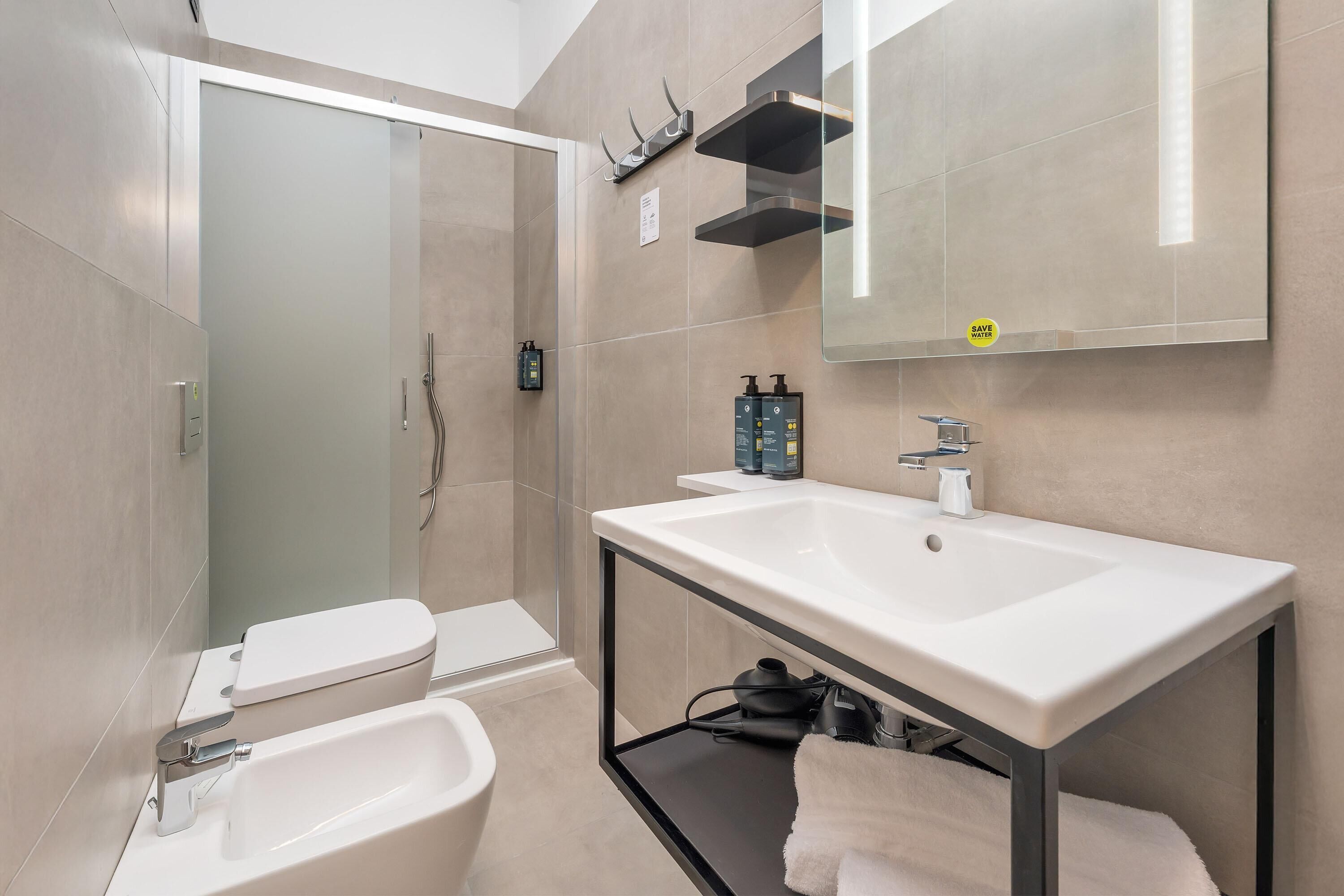 Une salle de bain moderne équipée de toilettes, d’un bidet et d’un lavabo.