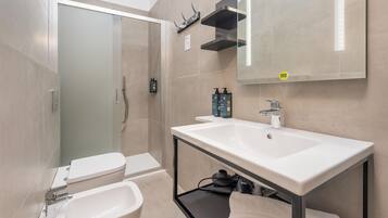 Une salle de bain moderne équipée de toilettes, d’un bidet et d’un lavabo.