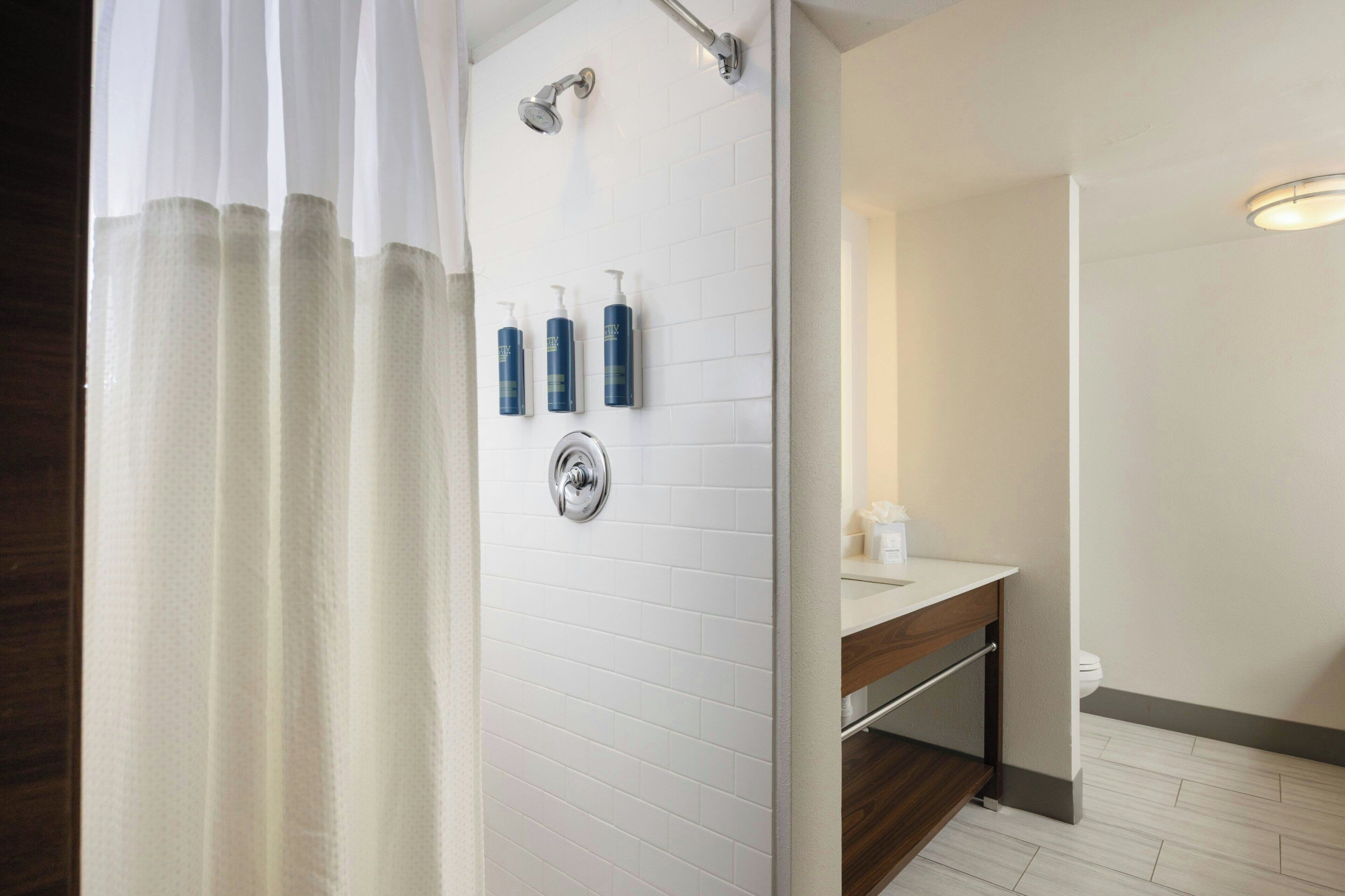 Une salle de bain moderne équipée d’une douche, de toilettes et d’un lavabo.