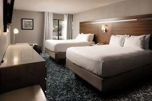 A hotel room with two beds, a desk, a chair, and a window with curtains. - Four Points by Sheraton Detroit Novi (Novi)