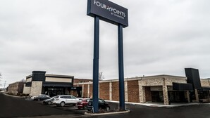 A Four Points by Sheraton sign with a parking lot and buildings in the background. - Four Points by Sheraton Detroit Novi (Novi)