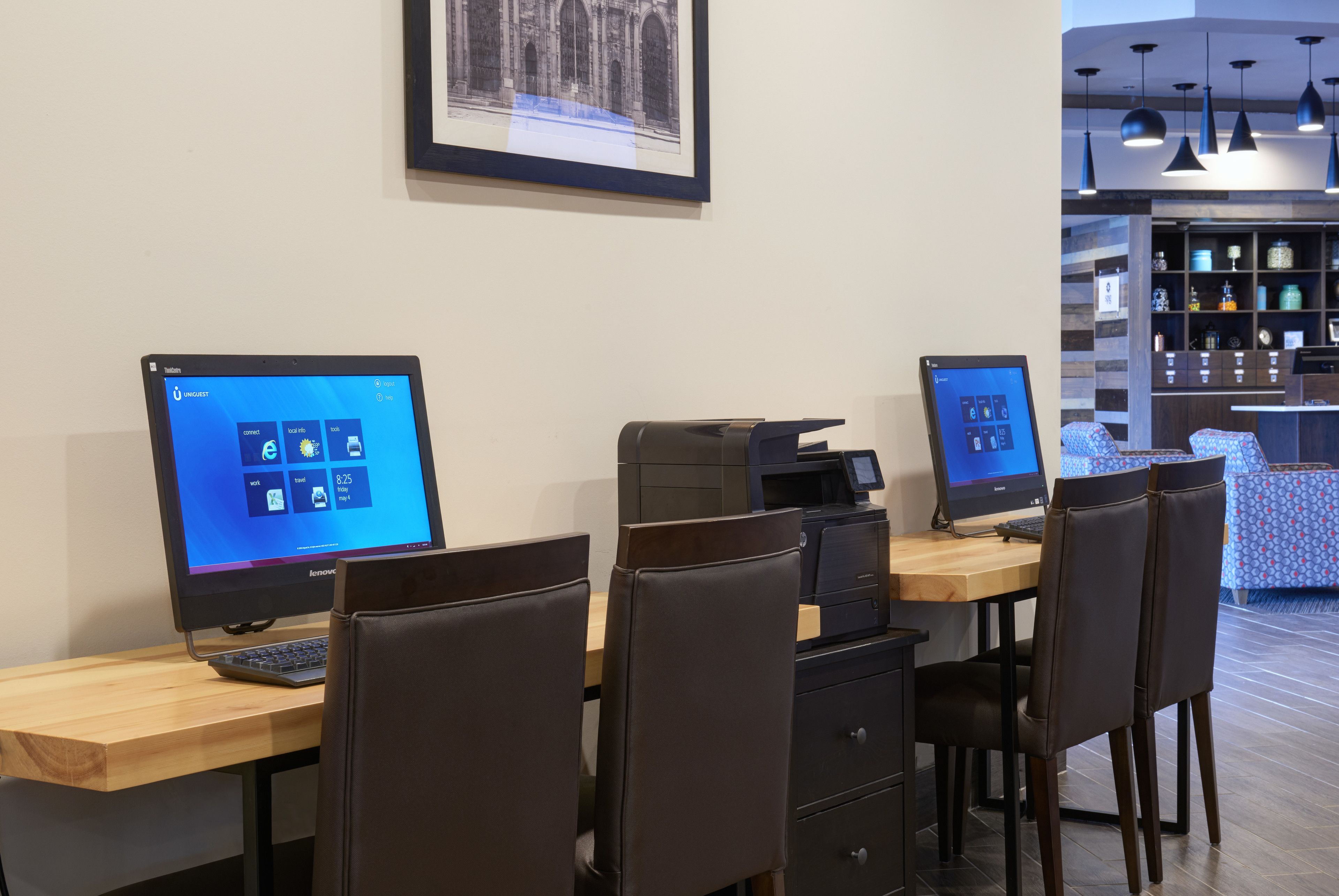 A workspace with two Lenovo computers, a printer, and a coffee machine.