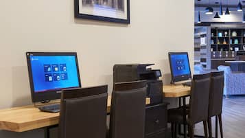 A workspace with two Lenovo computers, a printer, and a coffee machine.