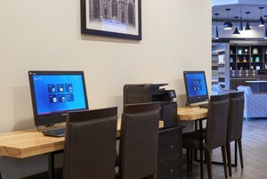 A workspace with two Lenovo computers, a printer, and a coffee machine.