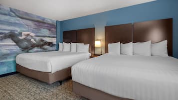 Una habitación de hotel con dos camas, un cuadro abstracto grande en la pared y una alfombra estampada.
