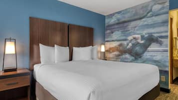 Habitación de hotel con una cama grande, dos mesitas de noche y un mural en la pared.