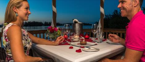 Un couple est assis à une table en plein air, profitant de la vue sur l’eau.