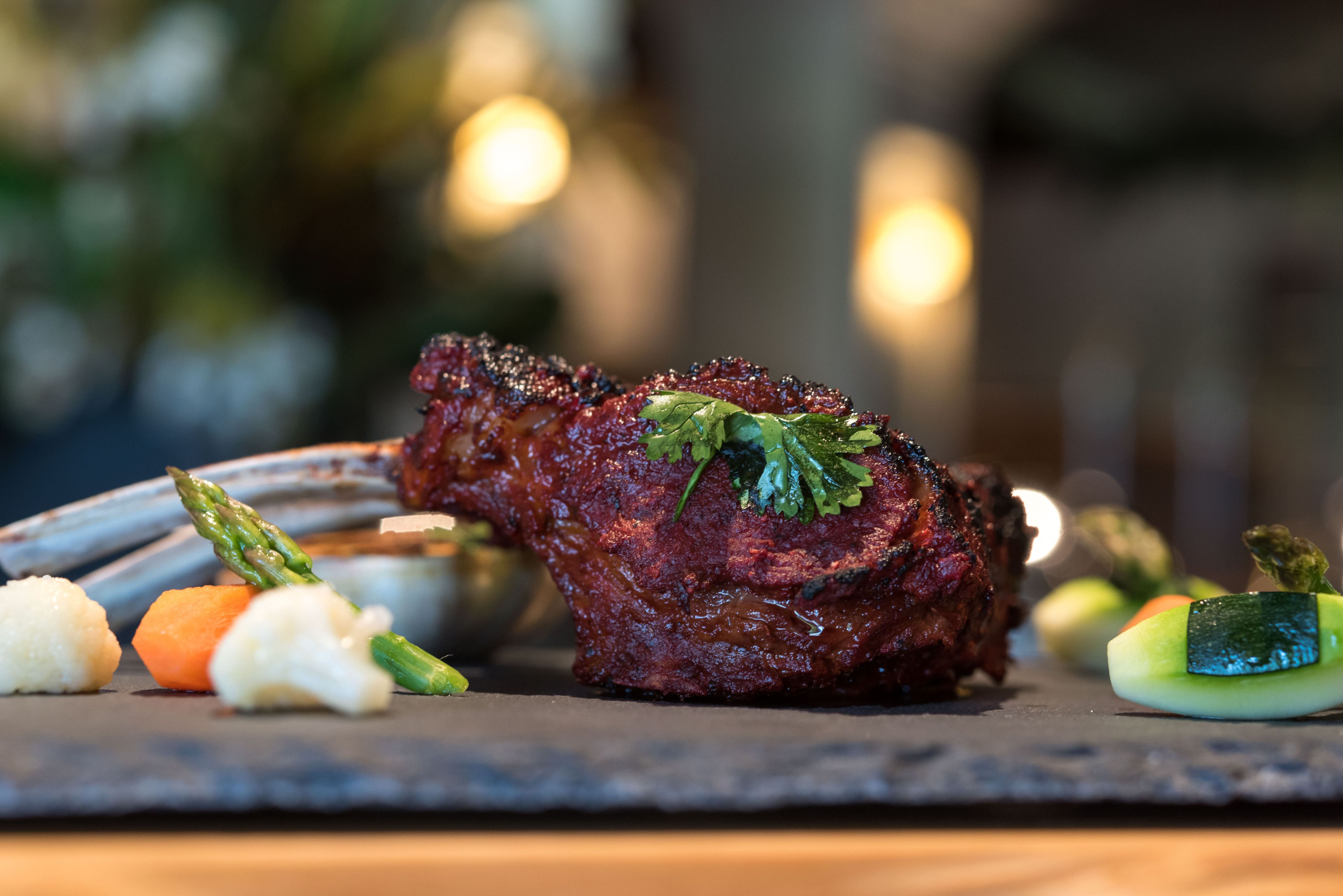 Een steak met groenten op een leisteenbord.