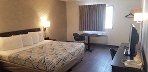 A hotel room with a large bed, a desk, a chair, a television, and a telephone. - Motel 6 Elk Grove Village, IL - O'Hare (Elk Grove Village)