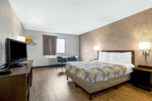 A hotel room with a bed, bedside table, TV, desk, and chair. - Motel 6 Elk Grove Village, IL - O'Hare (Elk Grove Village)