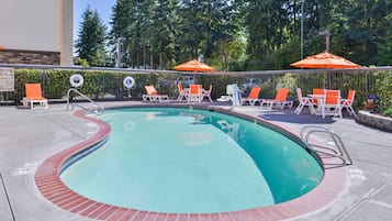 Una piscina al aire libre de temporada, sombrillas