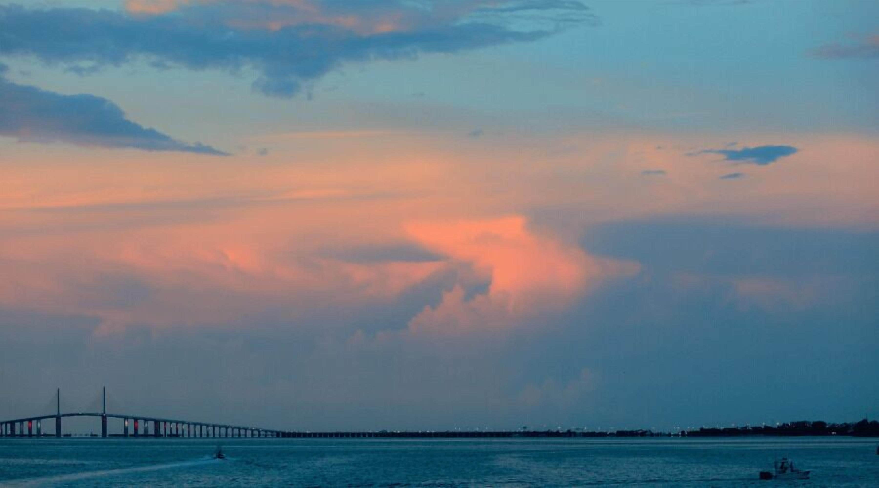 Un puente sobre un cuerpo de agua, con cielo despejado y nubes.