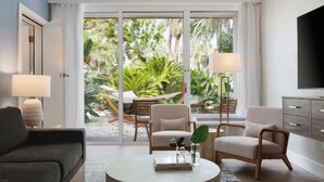 Una sala de estar moderna con un sofá, sillones, una mesa de centro y un televisor.