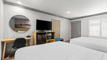 A hotel room with a bed, desk, television, and a view of the sky through a circular window.