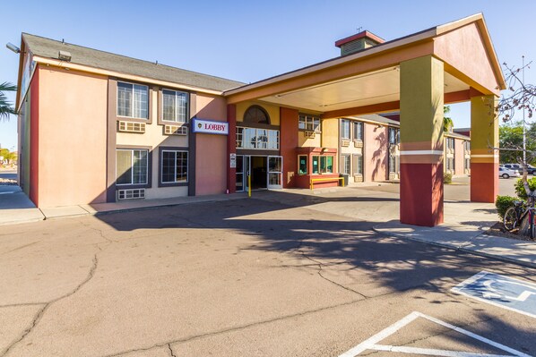 A building with a 'Lobby' sign, a covered entrance, and a parking area with a handicapped parking symbol.
