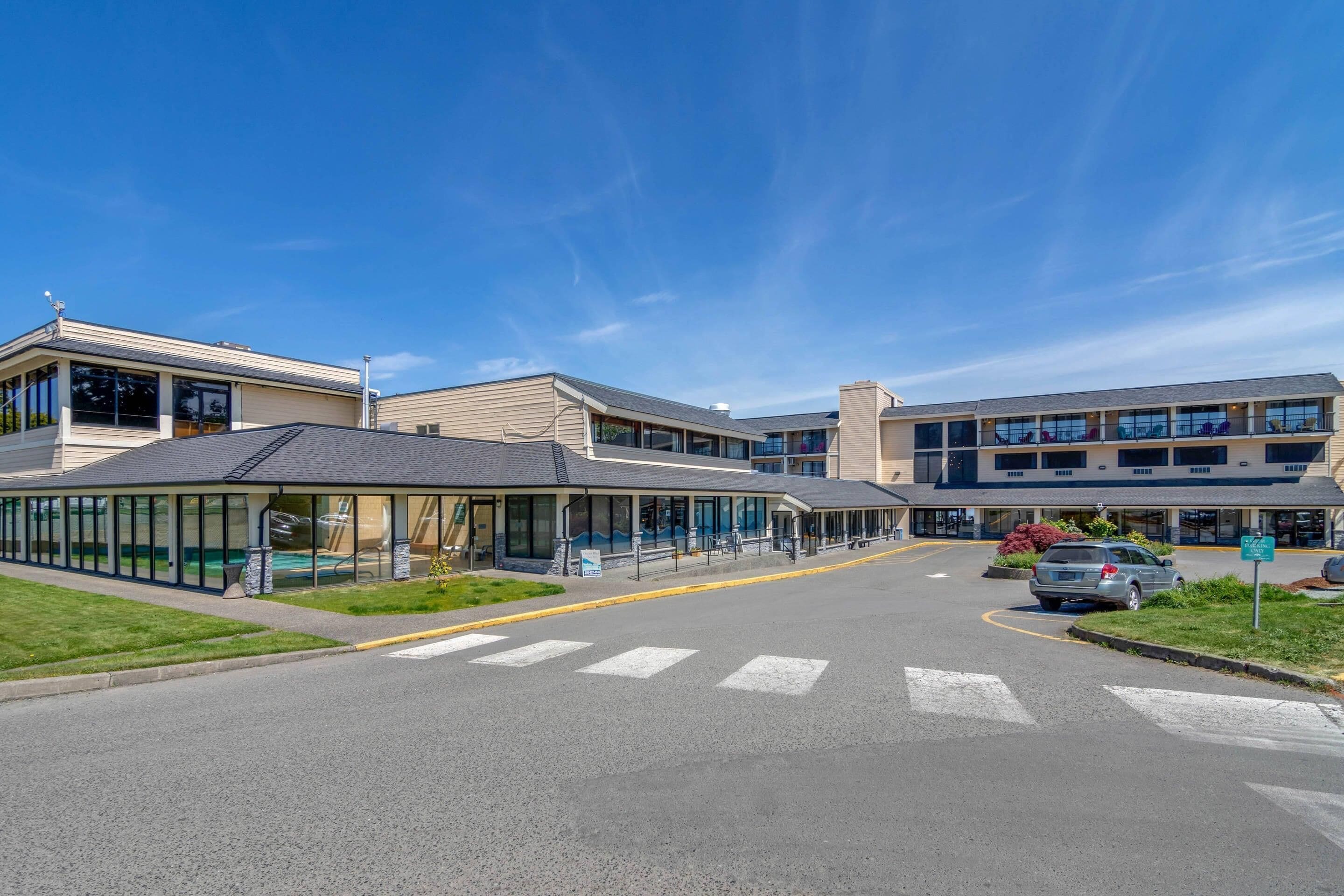 A modern building with a covered walkway and a parking lot.