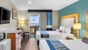 A hotel room with two beds, a TV, a desk, and a view of the ocean. - Howard Johnson by Wyndham Santa Cruz (Santa Cruz)
