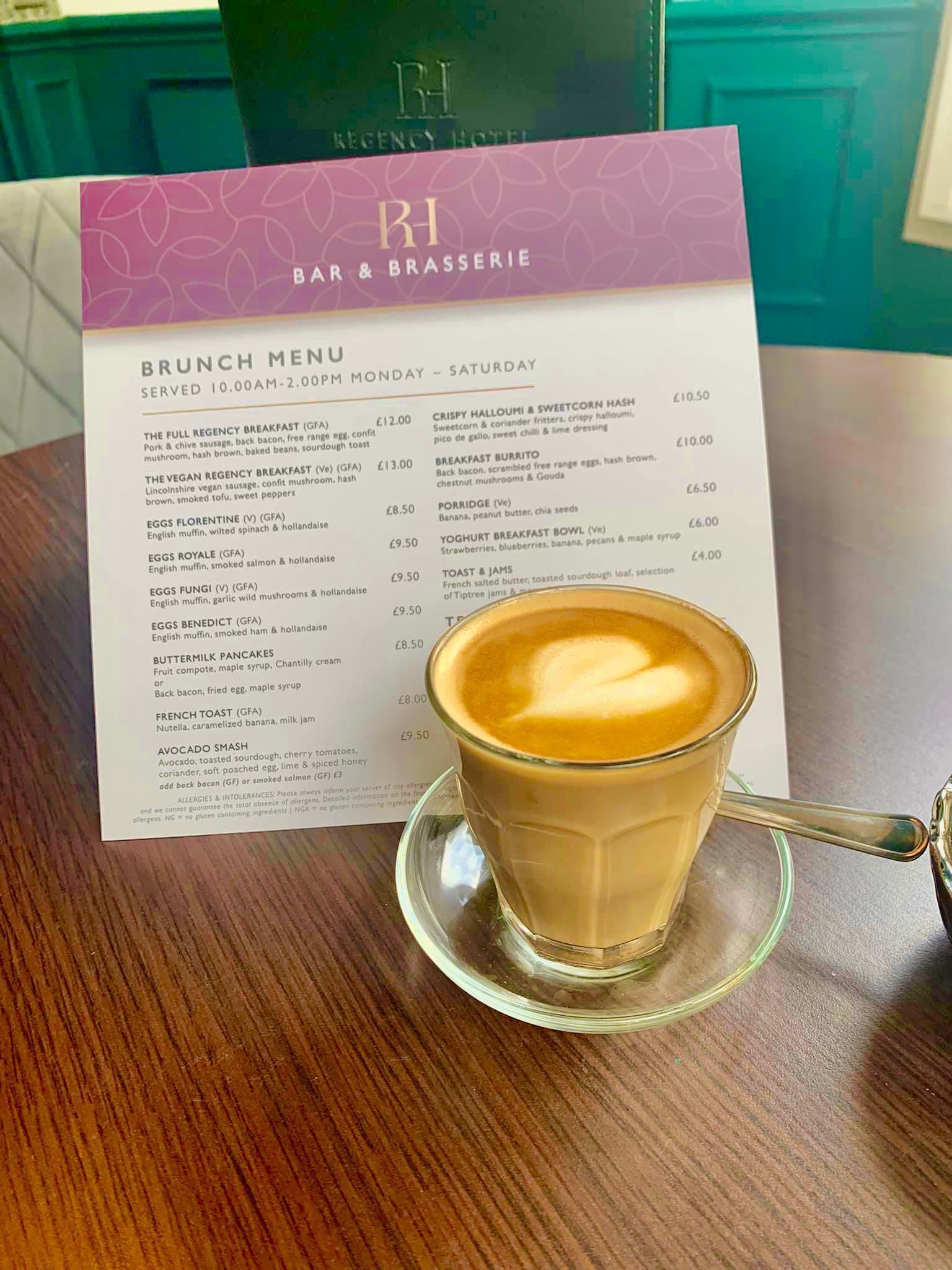 A brunch menu at a hotel bar and brasserie, with a cup of coffee on a saucer.
