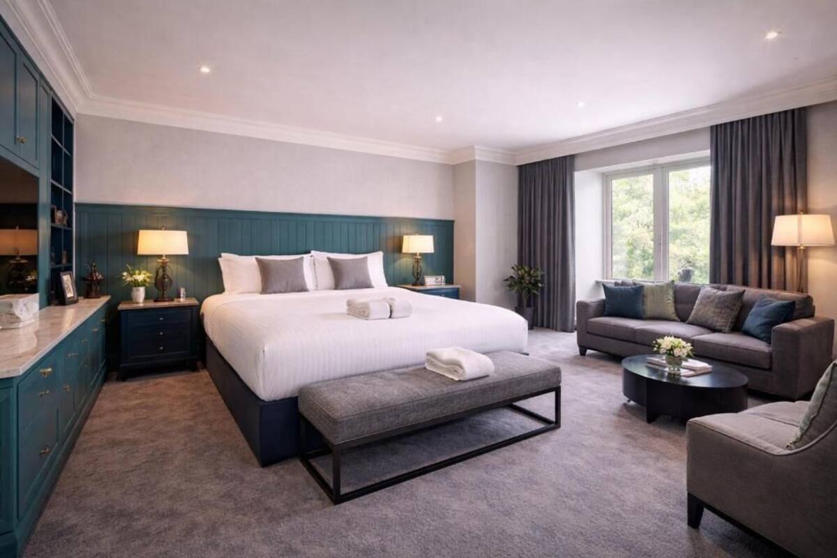 Ein modernes Hotelzimmer mit einem großen Bett, einer Couch, einer Bank und einem Couchtisch.