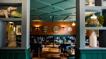 A restaurant interior with brick walls, blue ceiling, and wooden tables.