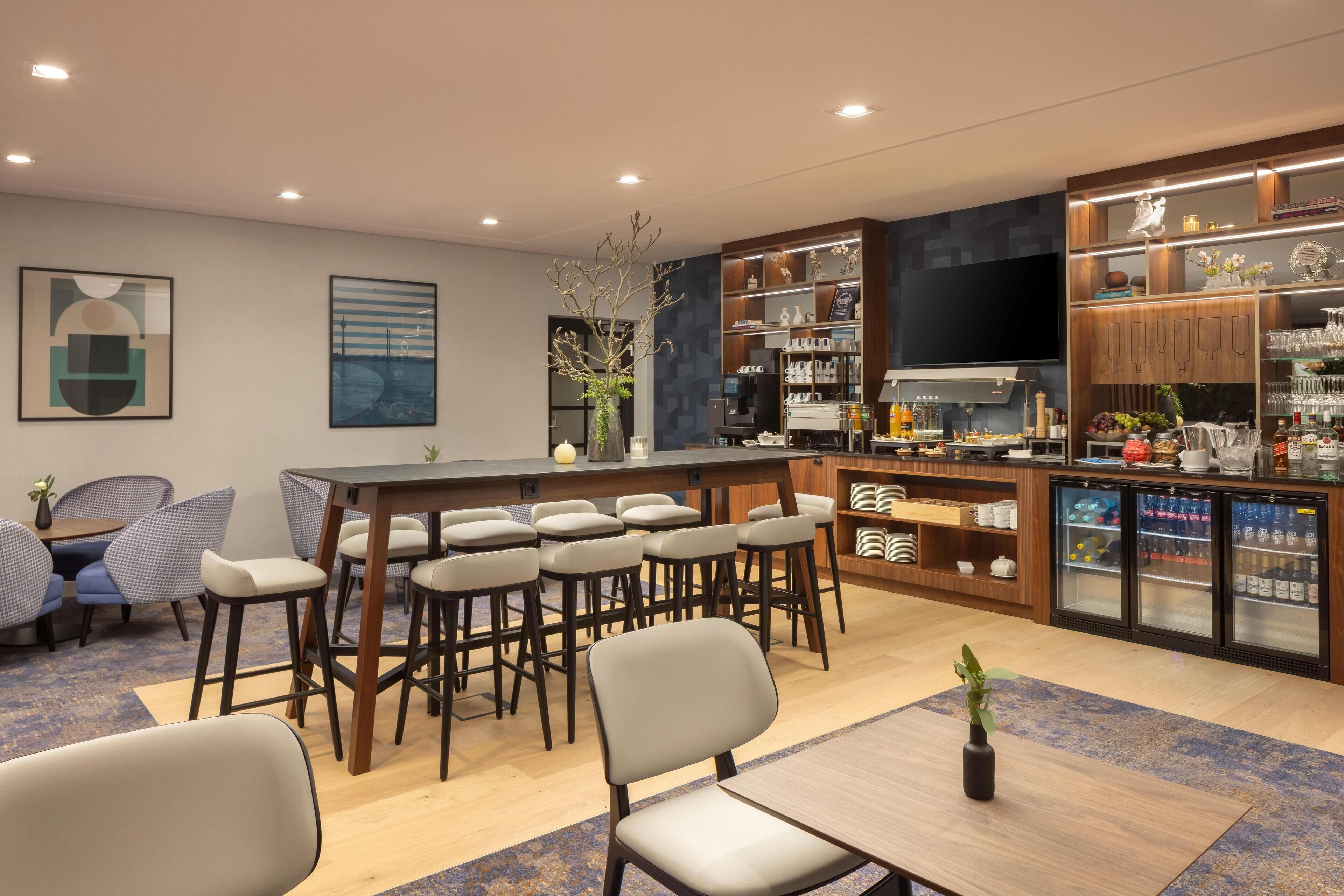 Een moderne keuken met barstoelen, een eettafel en een televisie.