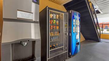 A vending machine with a variety of snacks and a sign advising against using ice to fill coolers.