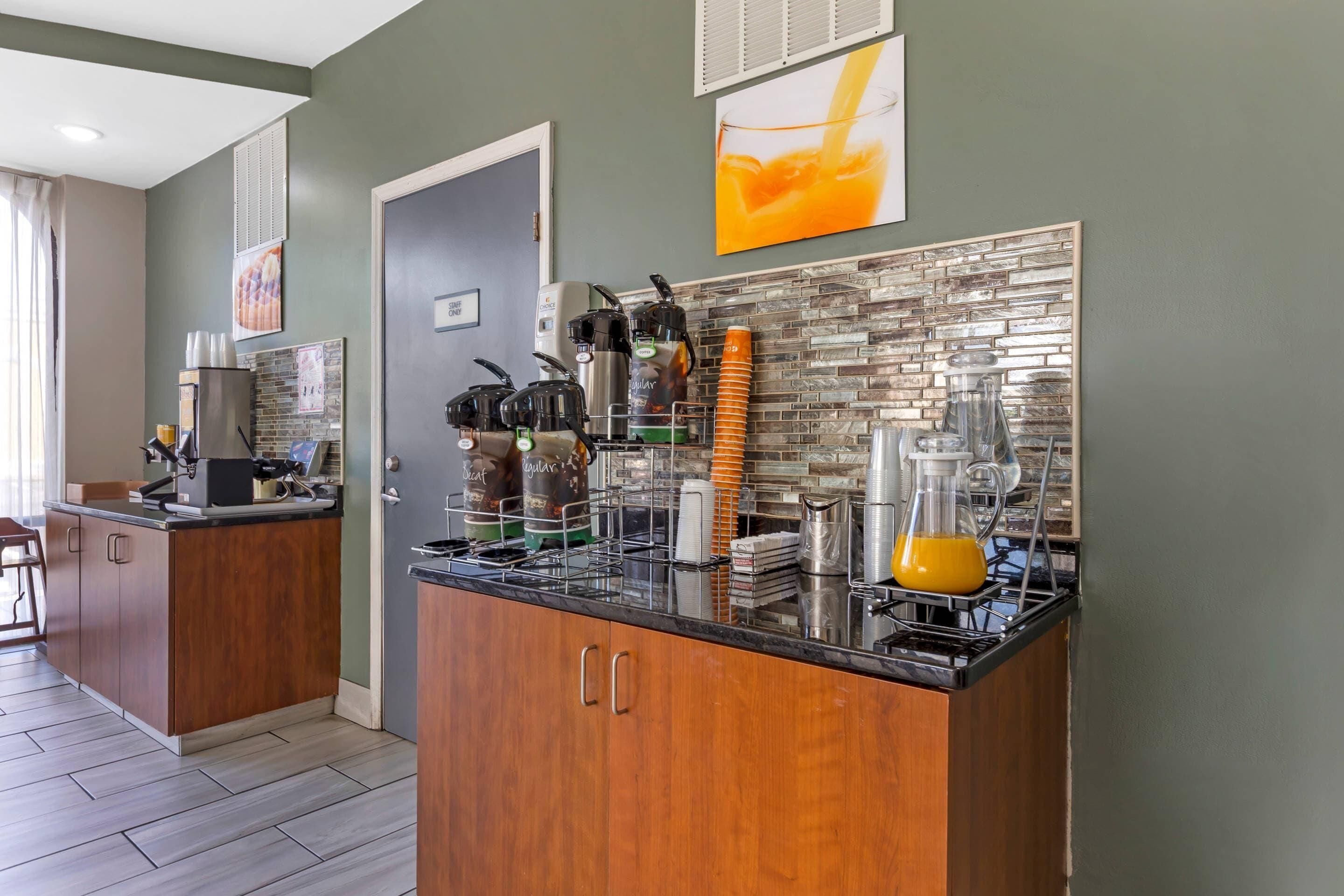 A modern kitchen with a black countertop, wooden cabinets, and a tiled backsplash.