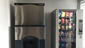Máquina expendedora con aperitivos y un dispensador de agua marca Scotsman.