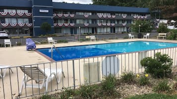 Una piscina al aire libre de temporada, sillones reclinables de piscina