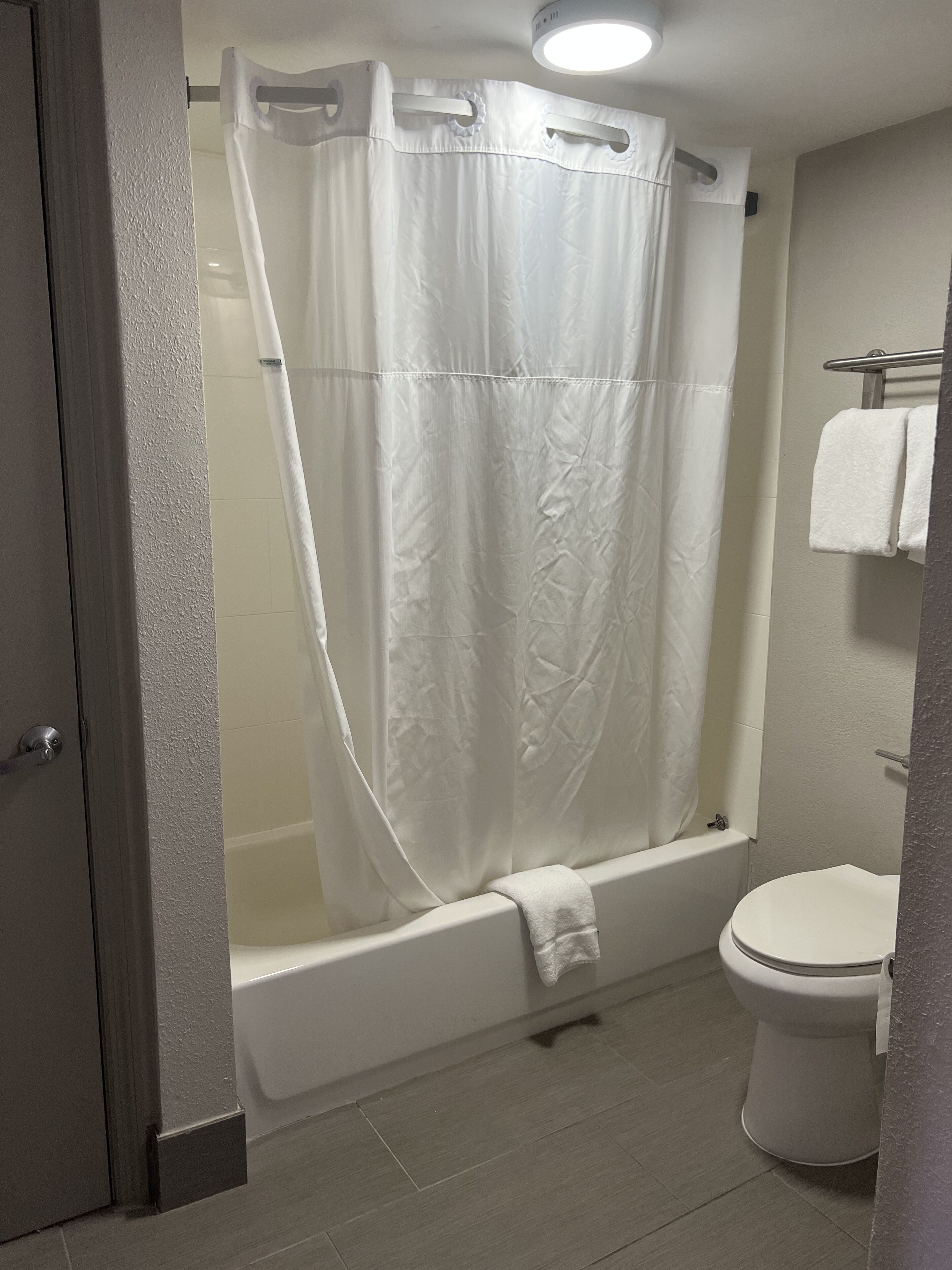 Un baño con bañera, inodoro y cortina de ducha.