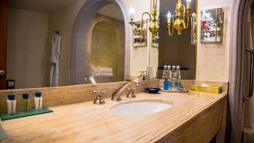 A bathroom with a large mirror, a sink, and a chandelier.