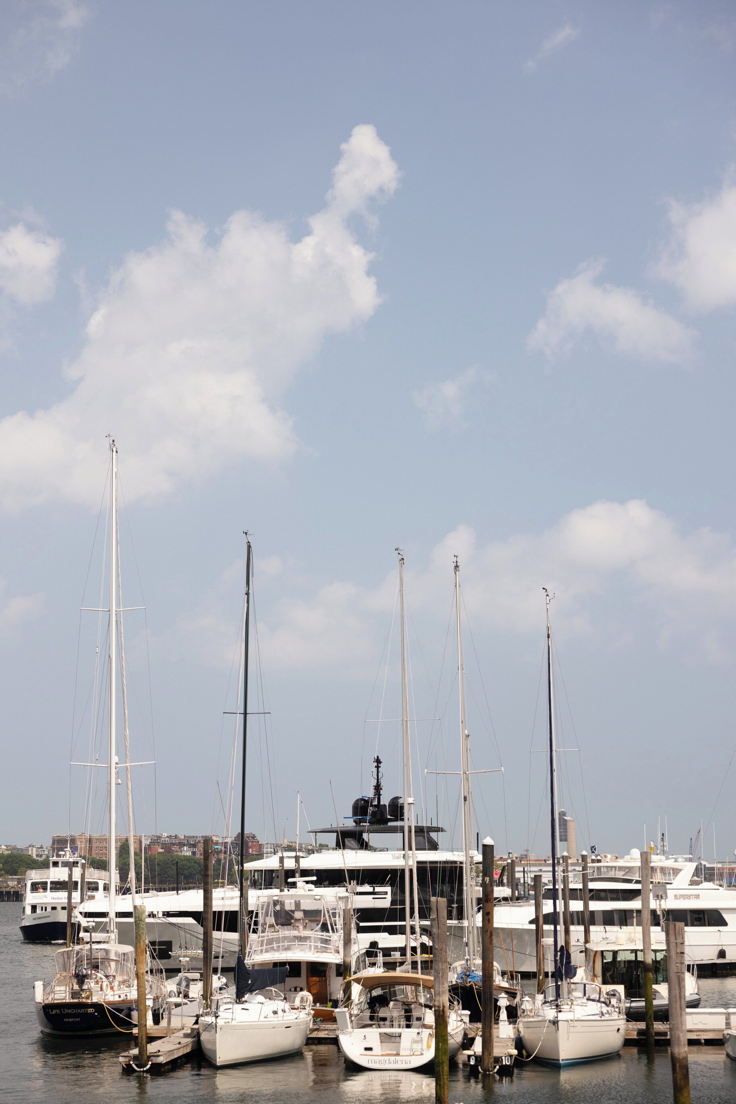 A marina with multiple sailboats docked at wooden piers.