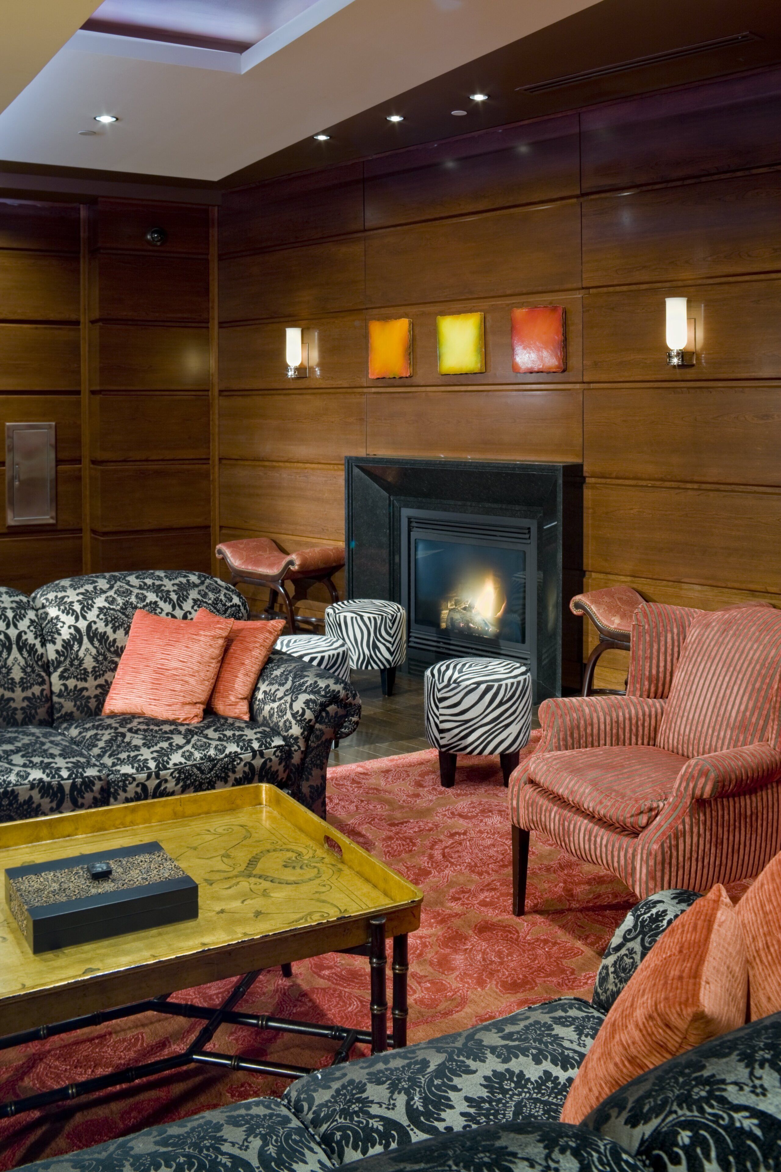 A cozy lounge area with patterned sofas, a small table, and a fireplace.