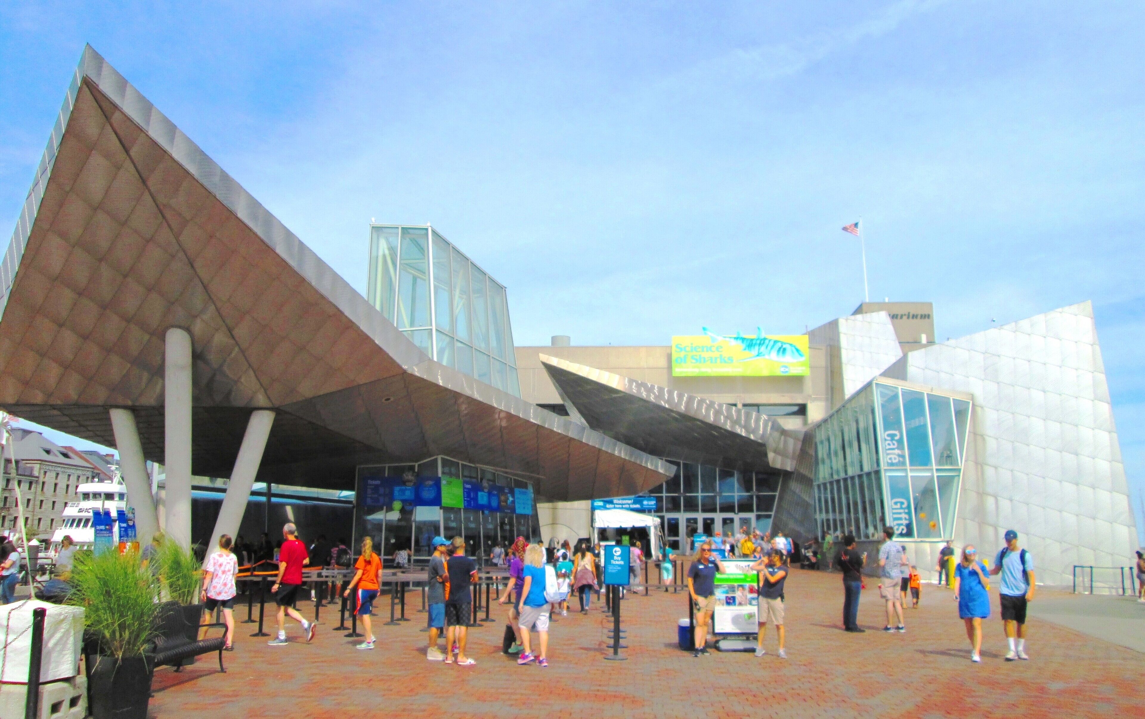A modern building with a unique architectural design, featuring a large glass facade and a distinctive roof structure.