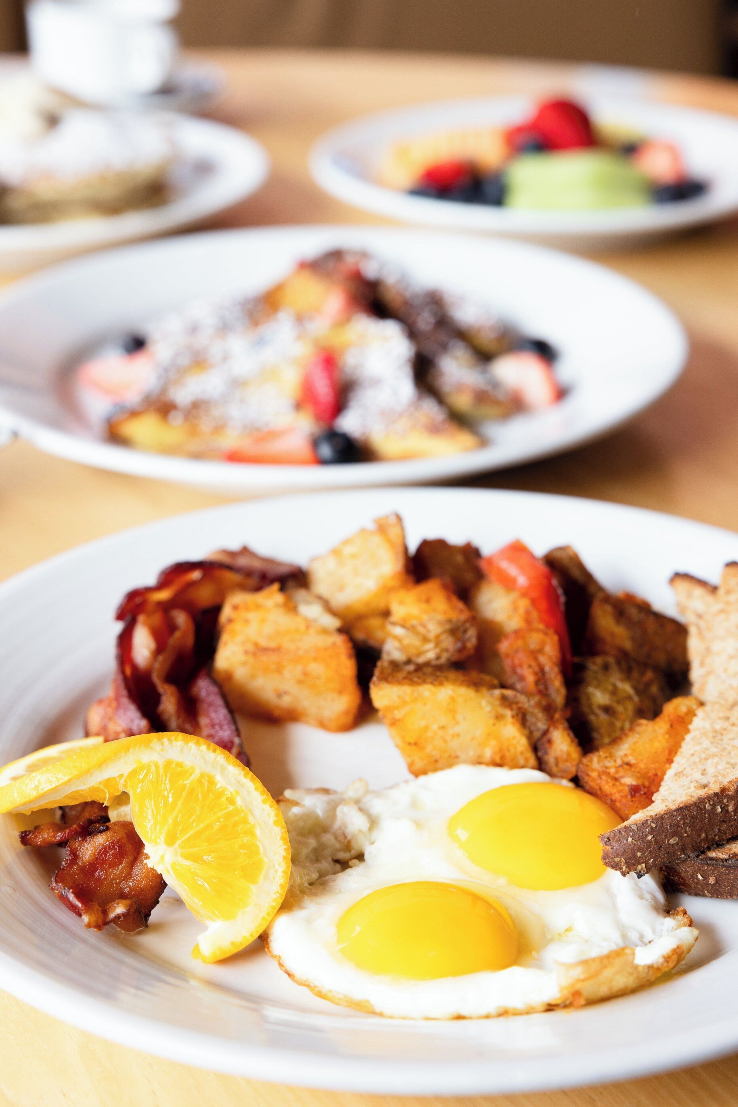 Ein Teller mit Frühstücksei, Speck, Toast und Orangenscheiben.