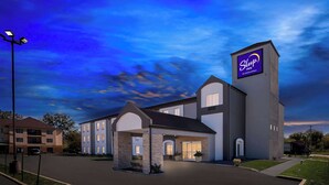 A Sleep Inn hotel with a modern design, featuring a large entrance, a parking lot, and a clear sky. - Sleep Inn Springfield West (Springfield)