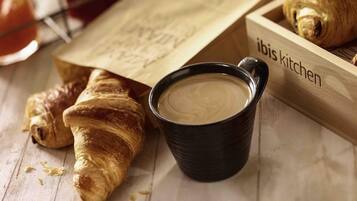 Ein Holztablett mit Croissants und einer Tasse Kaffee.