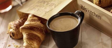 A wooden tray with croissants and a cup of coffee.