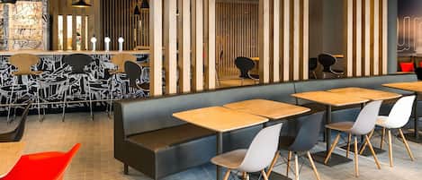 A modern restaurant interior with booths, tables, and chairs.