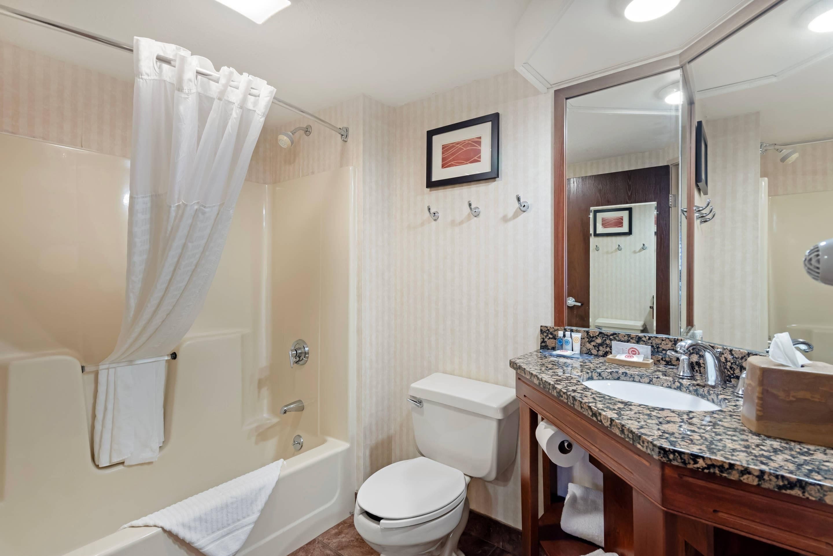 A bathroom with a bathtub, toilet, and sink.
