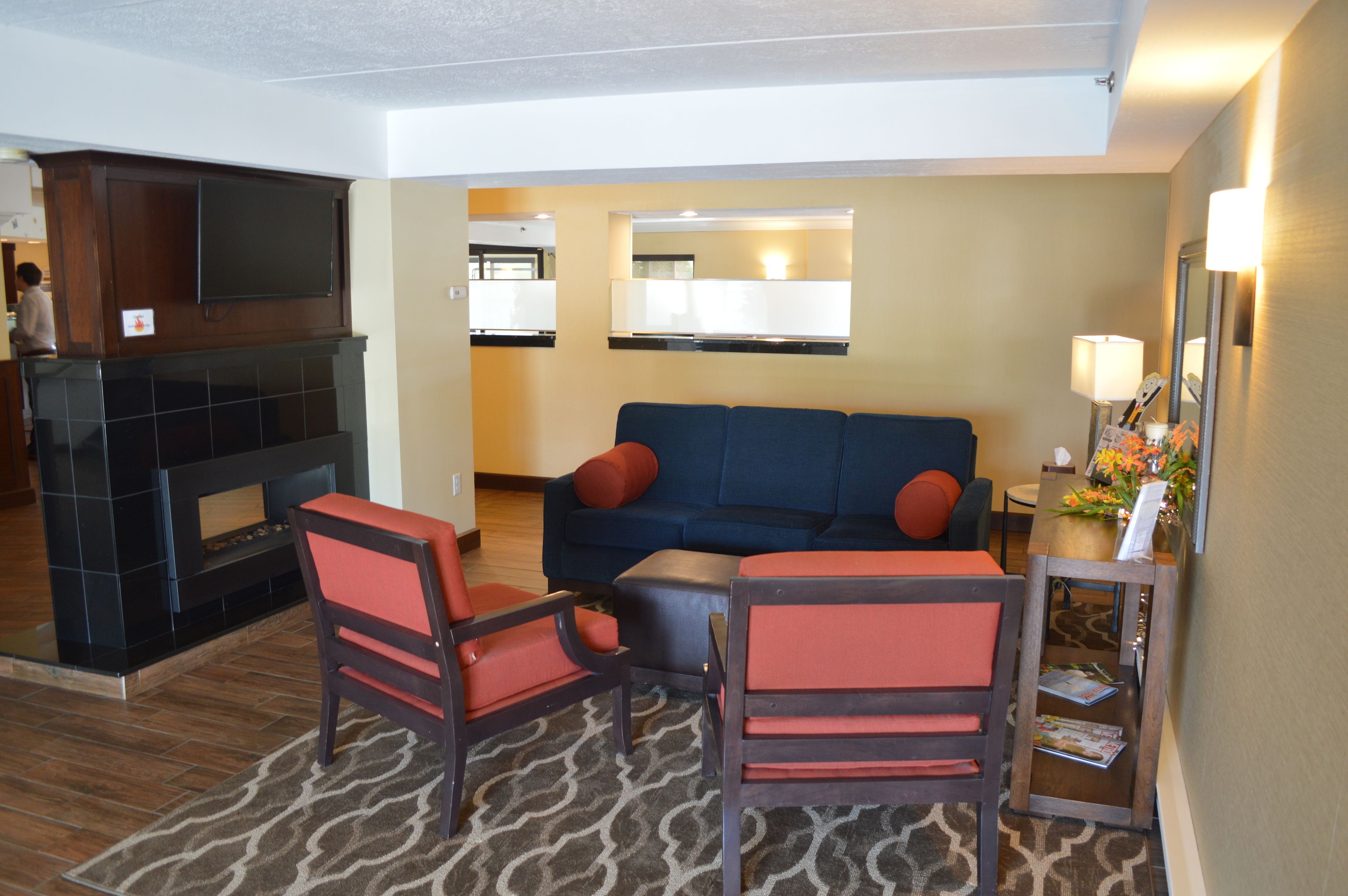A living room with a fireplace, a sofa, two armchairs, and a coffee table.